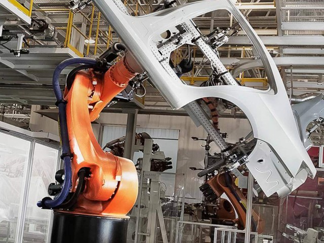 Roboter hebt Autokarosse