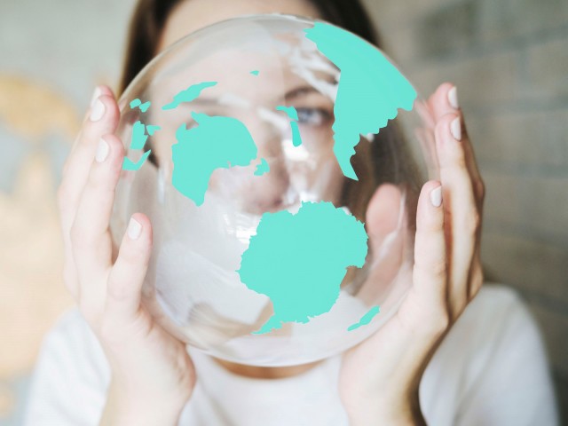 A woman holds a glass globe in her hands