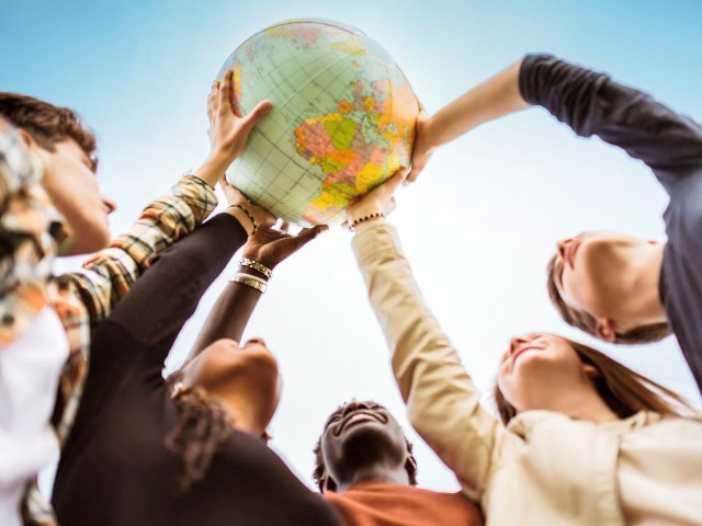 Young people hold a globe ball in their hands