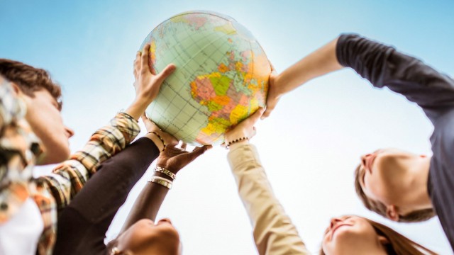 Young people hold a globe ball in their hands