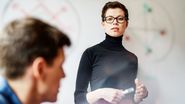 Junge Frau mit Rollkragenpullover blickt streng