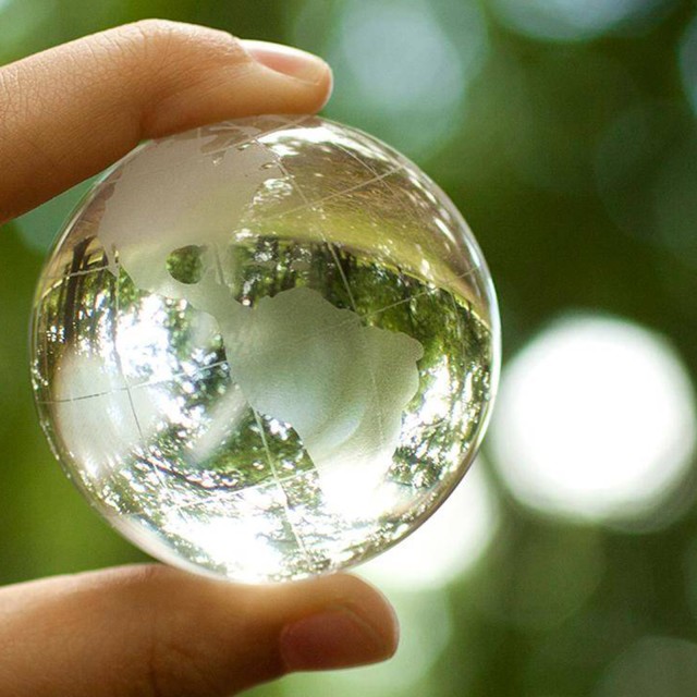 Glass globe in front of a green background