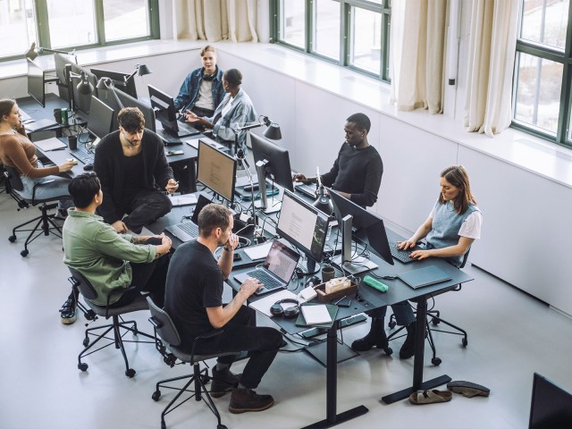 Junge Leute mit Laptops und Computern in lockerer Start-up-Atmosphäre